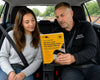 Driving instructor and learner reviewing ADI Part 3 test guide in car